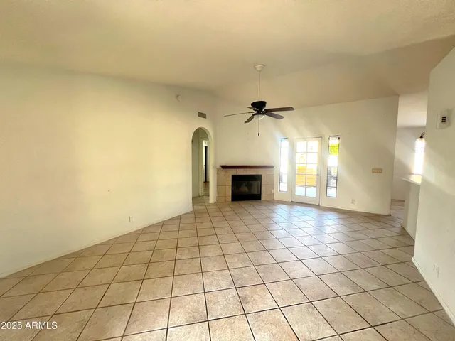 a view of empty room with a fireplace and wooden floor