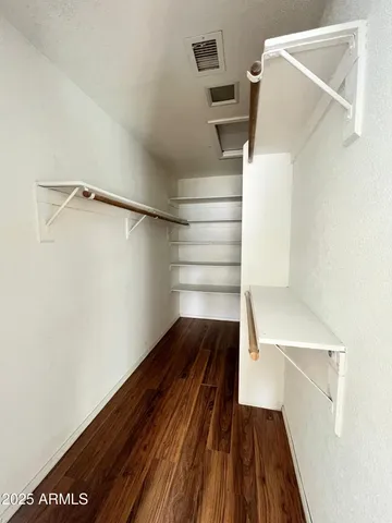 a view of walk in closet with empty racks