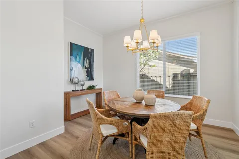 a dining room with furniture a chandelier and wooden floor