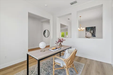 a view of a kitchen area with furniture and wooden floor