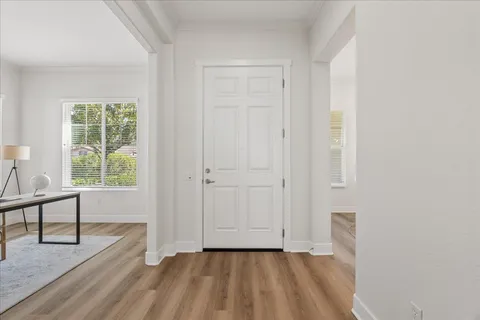 a view of a bedroom with wooden floor and windows