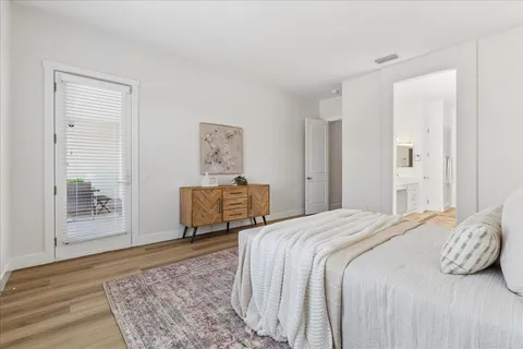 a bedroom with a bed and wooden floor