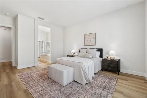 a bedroom with a bed and wooden floor