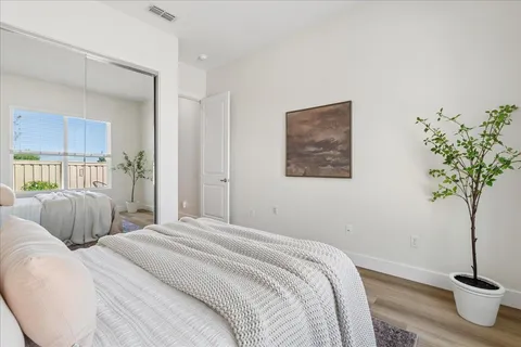 a bedroom with a bed and a potted plant
