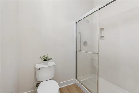 a bathroom with a granite countertop toilet and a shower
