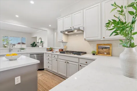 a kitchen with stainless steel appliances a white stove top oven and a white cabinets