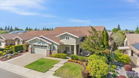 a front view of a house with a yard and trees