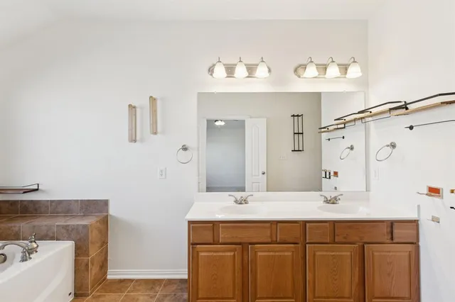 a bathroom with a tub sink and mirror