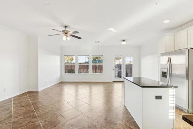 a view of a house next to a yard with plants and brick wall
