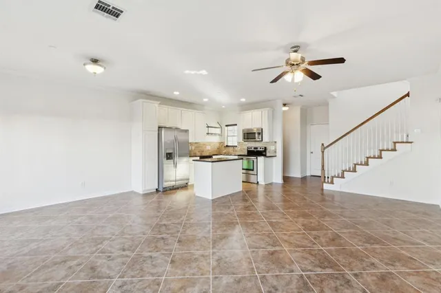 a kitchen with stainless steel appliances granite countertop a stove top oven a sink a counter space and cabinets