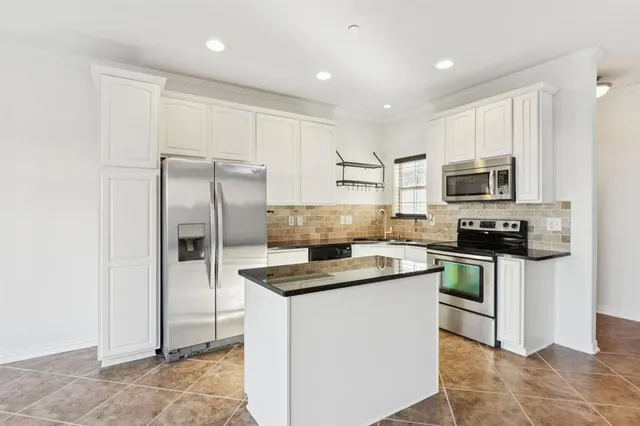 a view of kitchen with furniture and stainless steel appliances