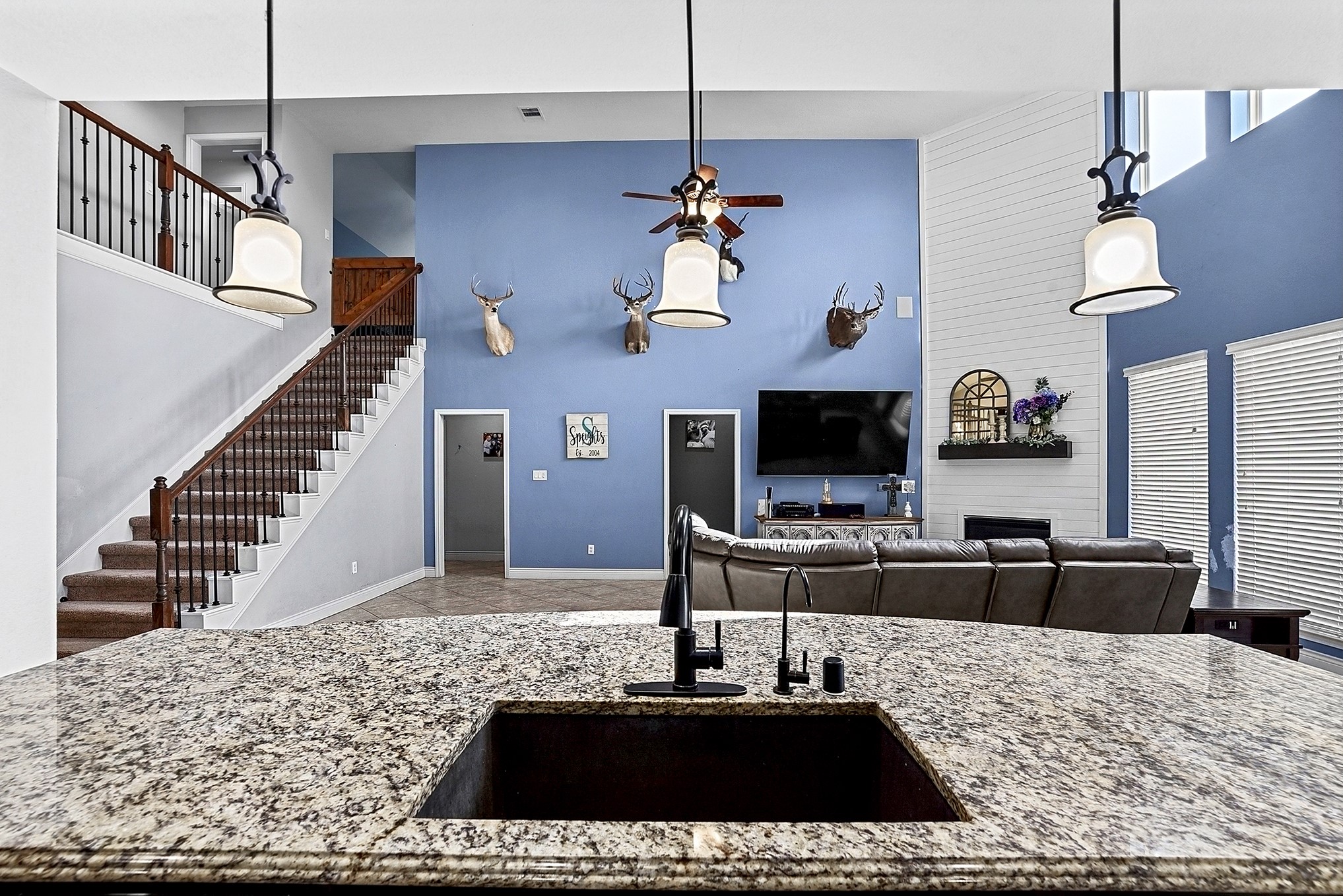 2951 Bobby Jones Road Katy, TX 77494 - Photo 19 of 50 View from the kitchen into the spacious living room, offering plenty of room to accommodate large furniture arrangements. Elevated ceilings create an open, airy feel, while the seamless flow between the kitchen and living area makes this space ideal for everyday living and entertaining. The convenient mudroom hallway nest to staircase provides easy access to the half bath, mudroom, and utility room, creating a practical transition between the main living areas and garage.