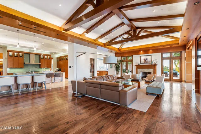 a view of a living room and kitchen with furniture wooden floor and a fireplace