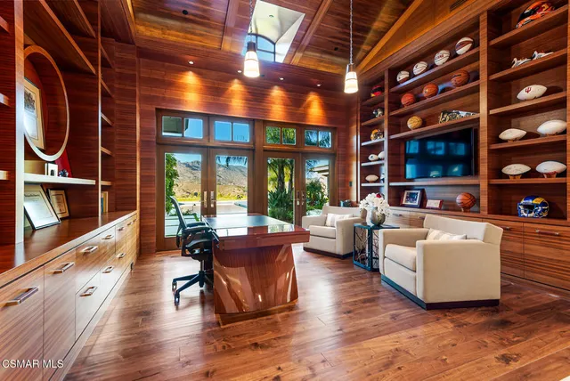 a living room with furniture a flat screen tv and floor to ceiling windows