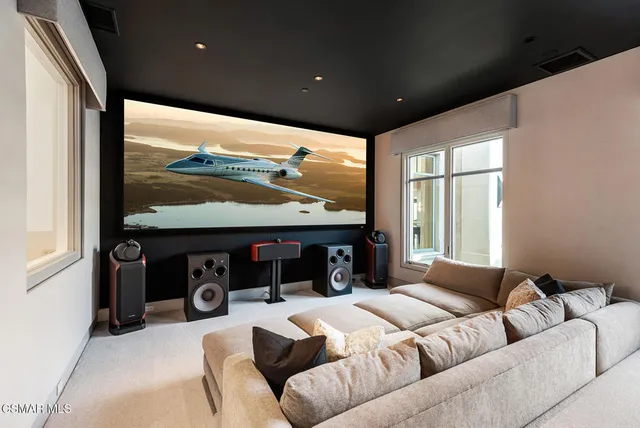 a living room with furniture a flat screen tv and a large window