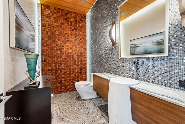 a bathroom with a granite countertop toilet sink and mirror