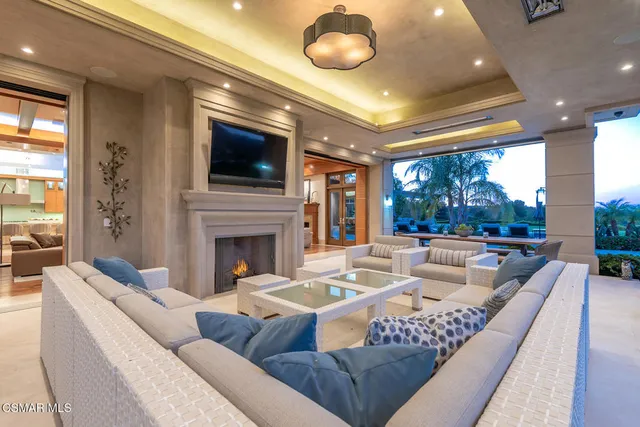 a living room with furniture a flat screen tv and a large window