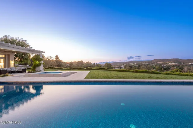 a view of swimming pool with outdoor seating and lake view
