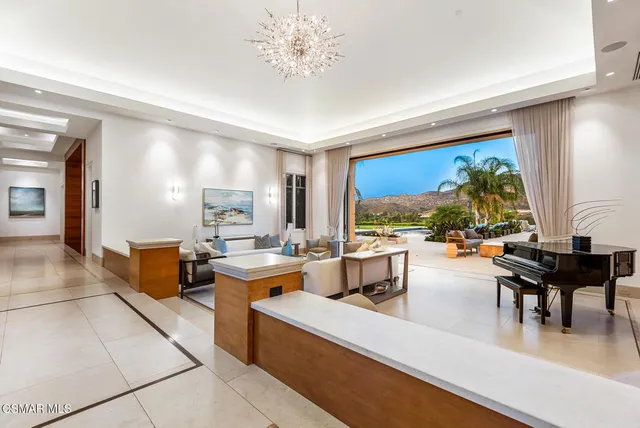 a living room with fireplace furniture and a large window