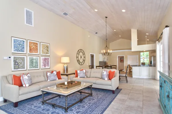 a view of a dining room and livingroom with furniture wooden floor a chandelier