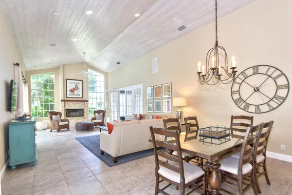 a view of a dining room and livingroom with furniture wooden floor a chandelier