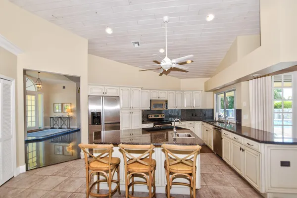 a kitchen with stainless steel appliances granite countertop a sink dishwasher a stove a refrigerator with island cabinets and wooden floor