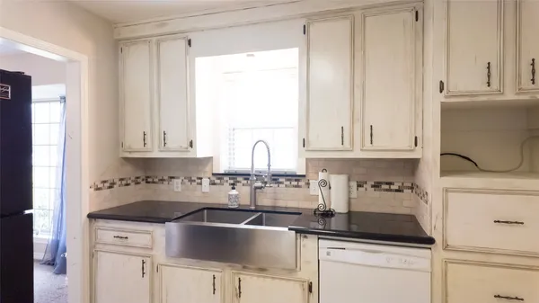 a kitchen with white cabinets and a sink