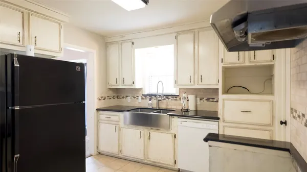 a kitchen with a refrigerator sink and cabinets