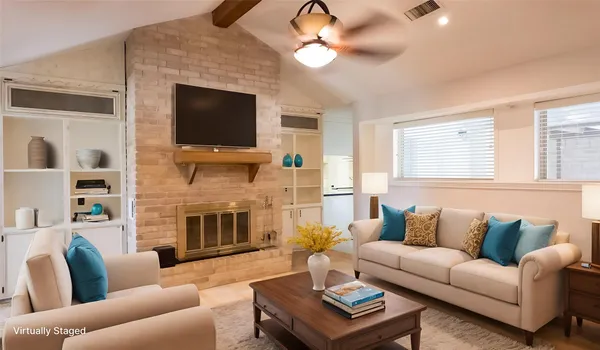 a living room with furniture a flat screen tv and a fireplace