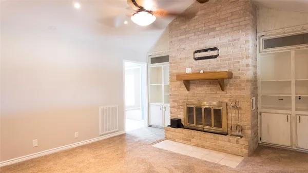 a view of a livingroom with a fireplace and a ceiling fan