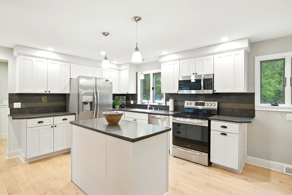 3 Pine Knoll Road Southwick, MA 01077 - Photo 12 of 42 a kitchen with stainless steel appliances a stove sink microwave refrigerator and cabinets