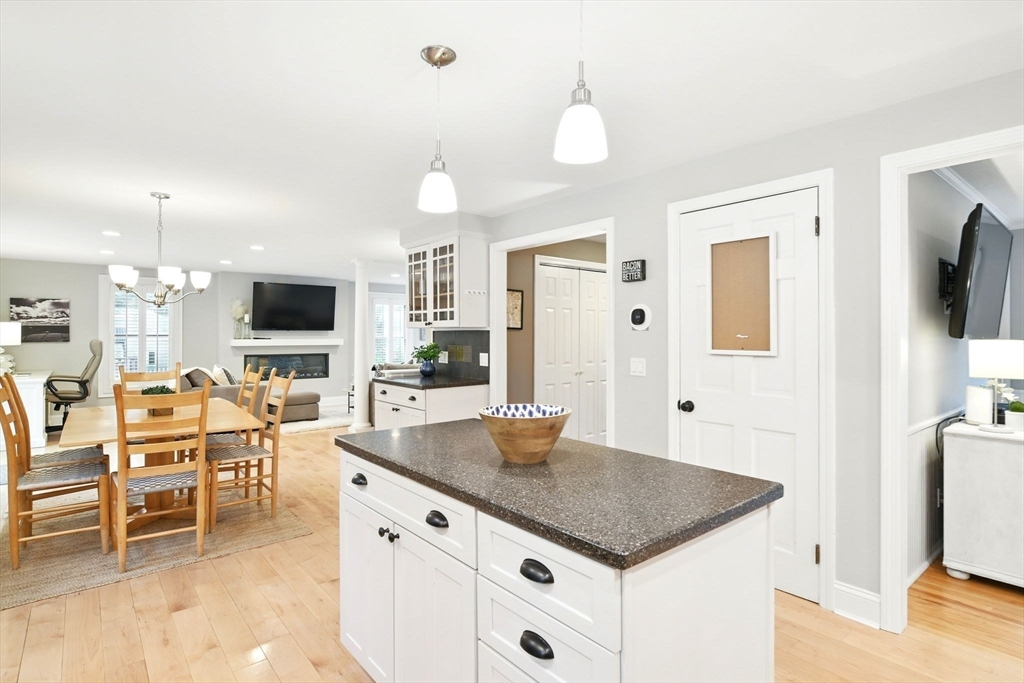 3 Pine Knoll Road Southwick, MA 01077 - Photo 13 of 42 a kitchen with stainless steel appliances granite countertop a stove top oven a sink a dining table and chairs with wooden floor