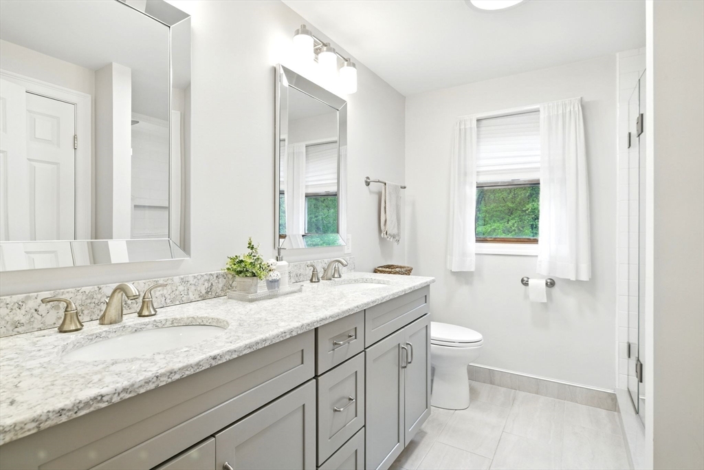 3 Pine Knoll Road Southwick, MA 01077 - Photo 27 of 42 a bathroom with a granite countertop sink mirror and a toilet