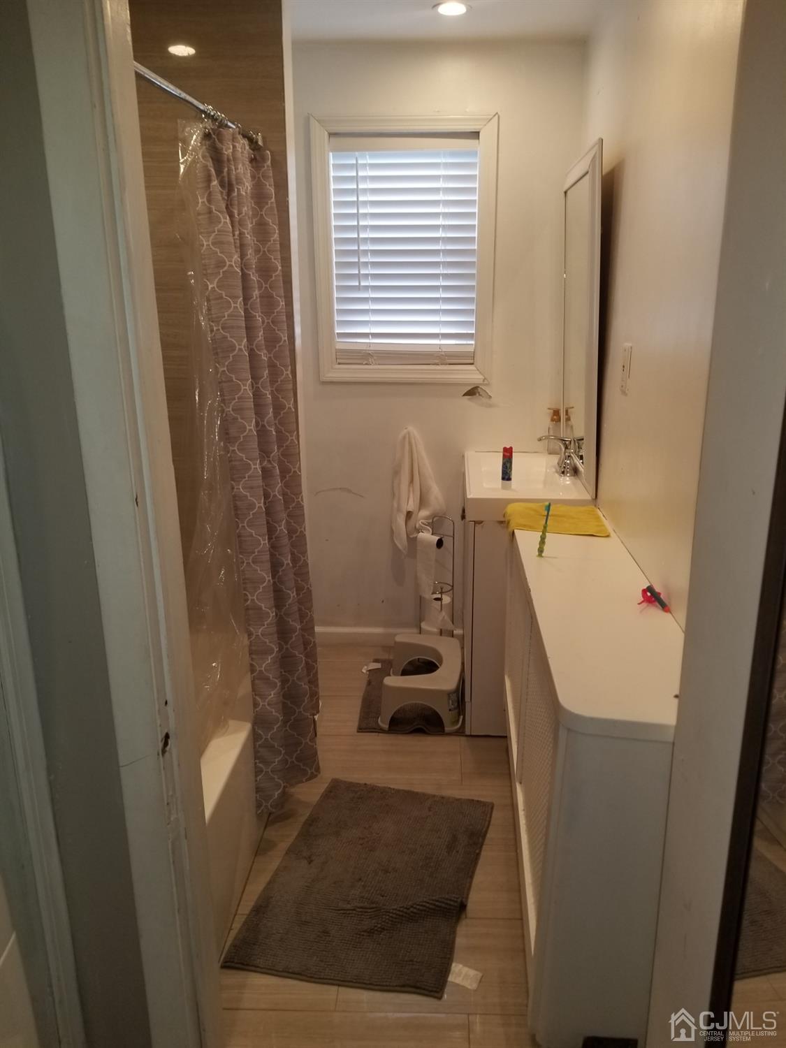 118 Rector Street Perth Amboy, NJ 08861 - Photo 11 of 12 a bathroom with a sink a bath tub and a window