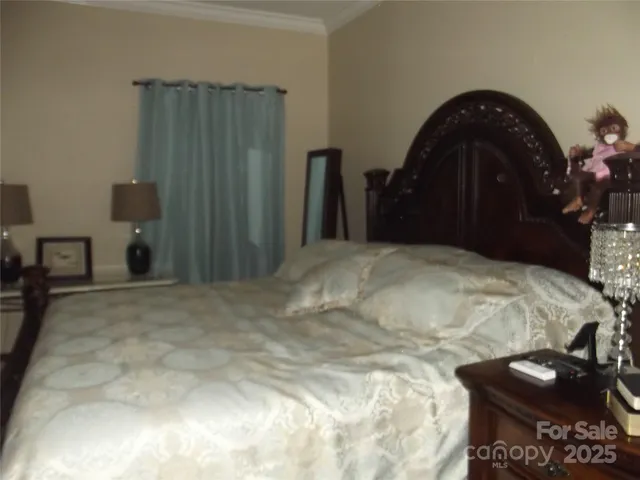 a bed sitting in a bedroom and bedroom with a mirror