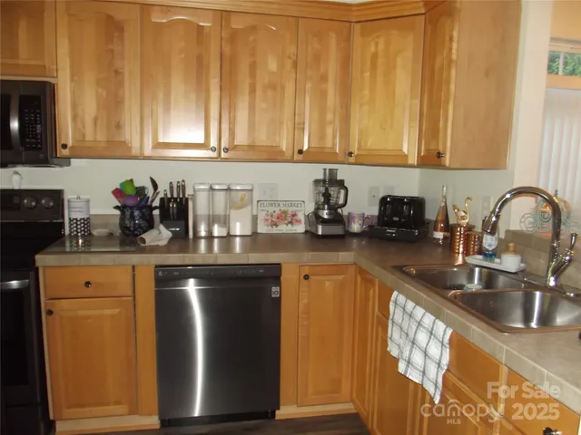 a kitchen with stainless steel appliances granite countertop a sink a stove and a microwave