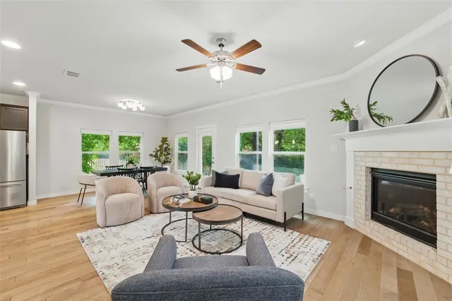 a living room with furniture a fireplace window and wooden floor
