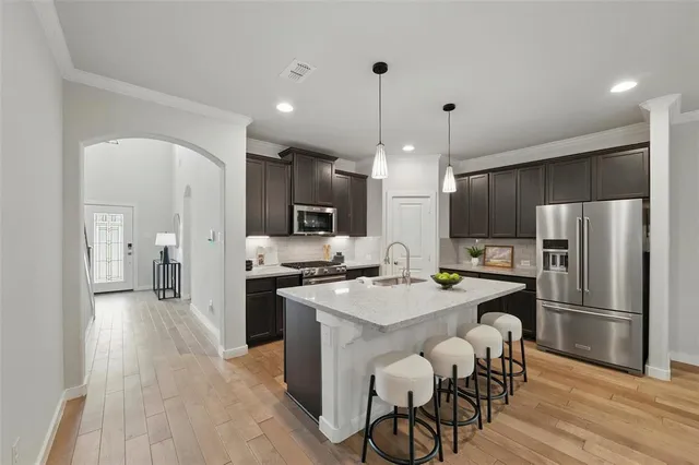 a kitchen with stainless steel appliances a stove a refrigerator a sink and a refrigerator