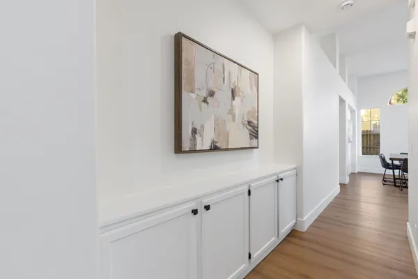 a view of a hallway with wooden floor and closet