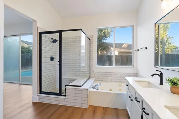 a bathroom with a tub sink and mirror