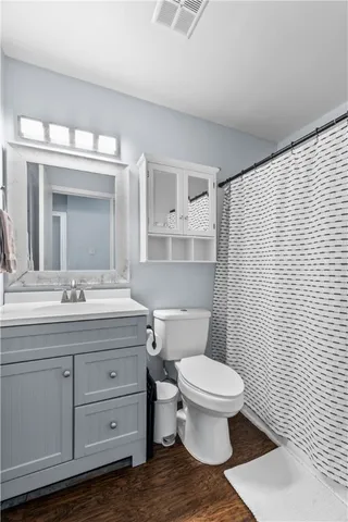 a bathroom with a granite countertop toilet sink and mirror
