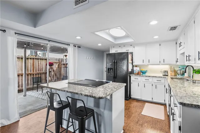 a kitchen with stainless steel appliances granite countertop a kitchen island a stove a table and chairs