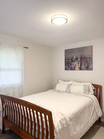 a bedroom with a bed and a painting on the wall
