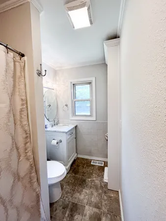 a bathroom with a granite countertop toilet a sink and a mirror