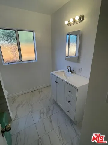 a spacious bathroom with a double vanity sink a mirror and a shower