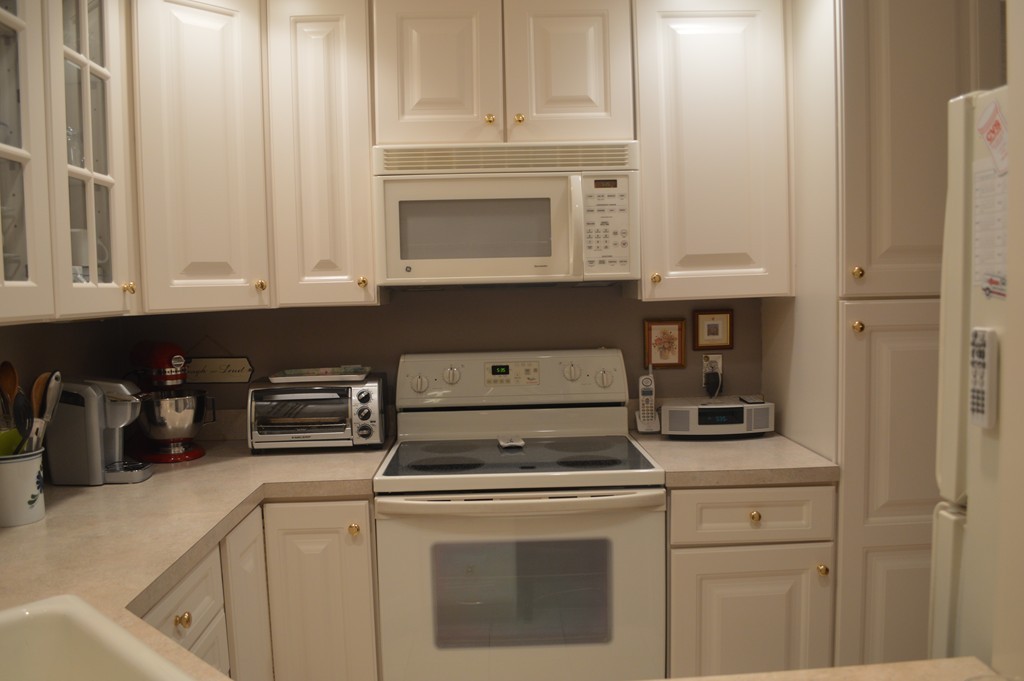 64 Jacqueline Road, Unit 5 Waltham, MA 02452 - Photo 2 of 10 a kitchen with white cabinets and white appliances