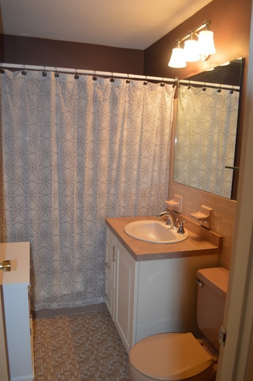 64 Jacqueline Road, Unit 5 Waltham, MA 02452 - Photo 4 of 10 a bathroom with a sink and a mirror