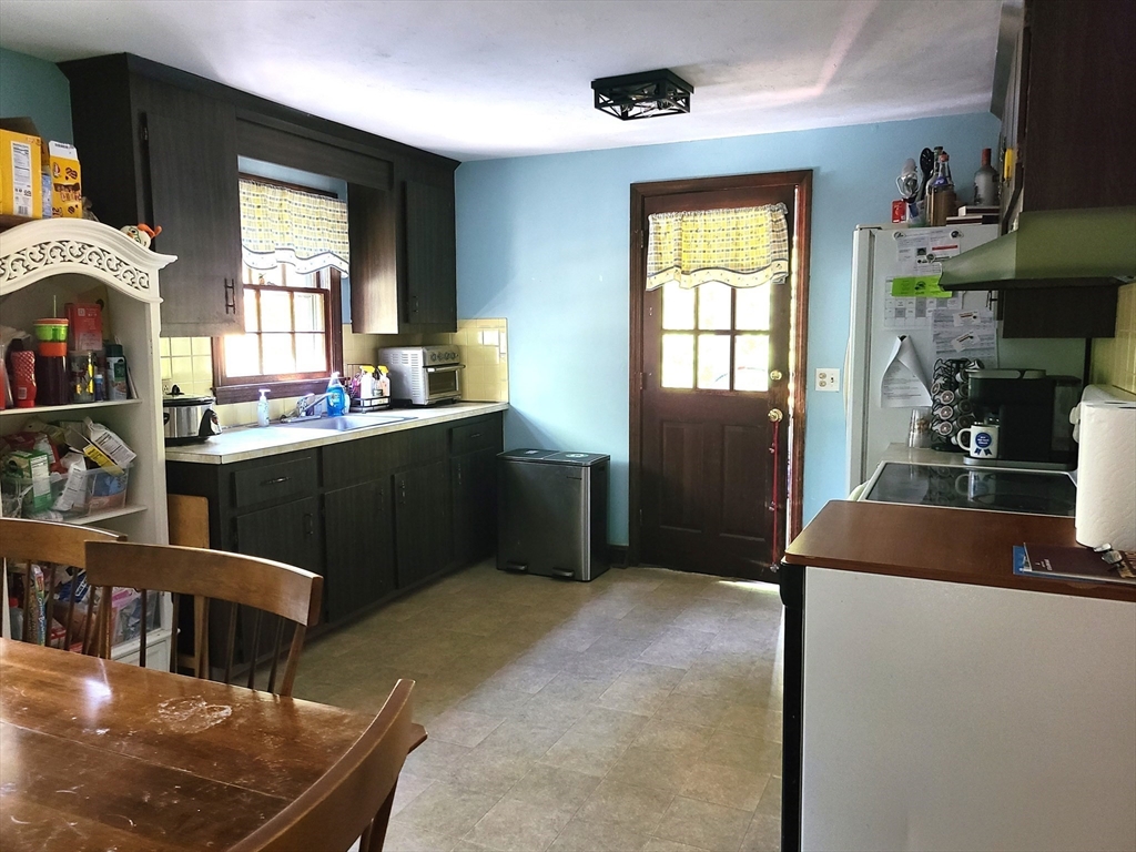 131 Holly Ridge Drive Hanson, MA 02341 - Photo 12 of 36 a kitchen with stainless steel appliances granite countertop a stove a sink a refrigerator and a dining table with wooden floor