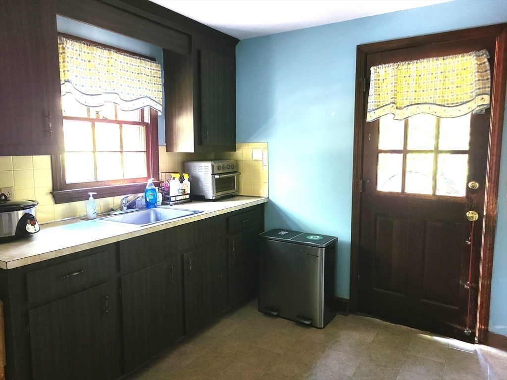 131 Holly Ridge Drive Hanson, MA 02341 - Photo 10 of 36 a kitchen with a window wooden cabinets and a sink
