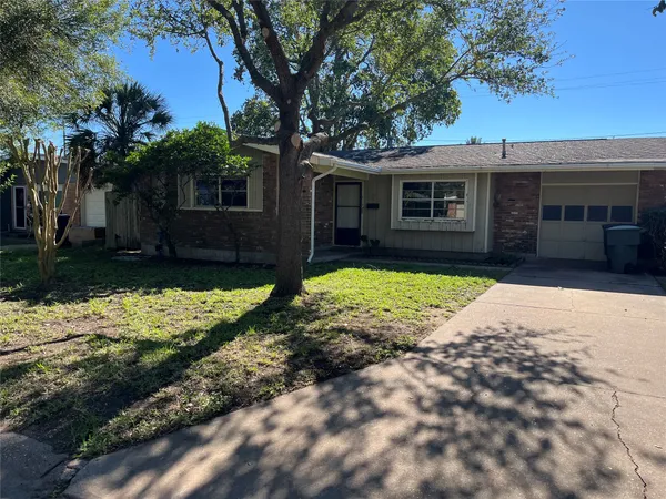 a front view of a house with a yard and trees